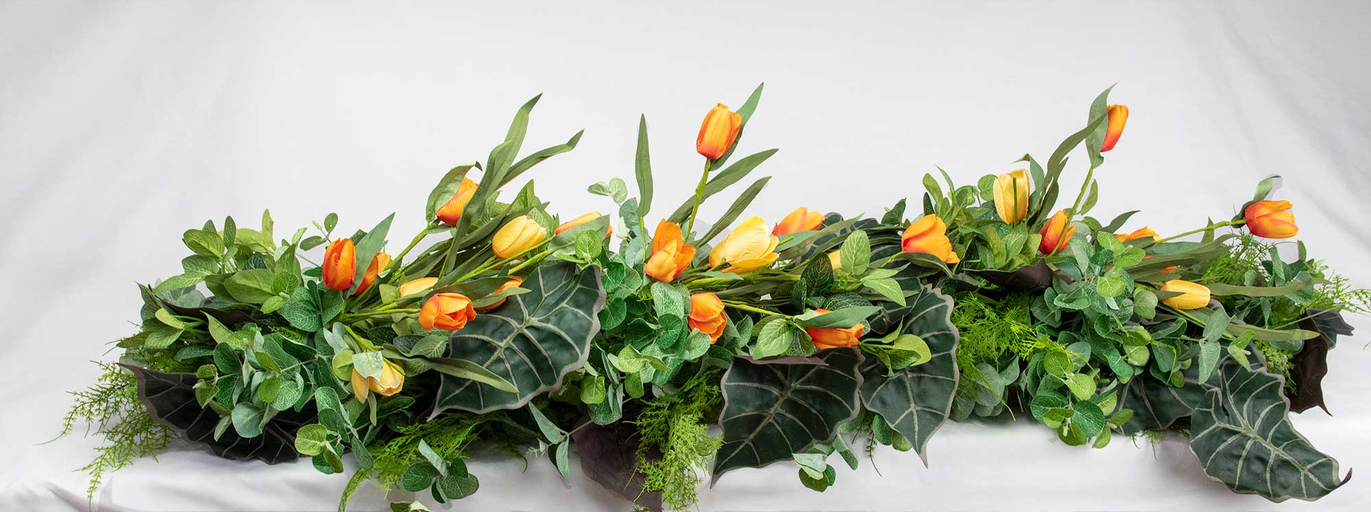 Bridal Table Runners in green with added Foliage and yellow & orange tulips