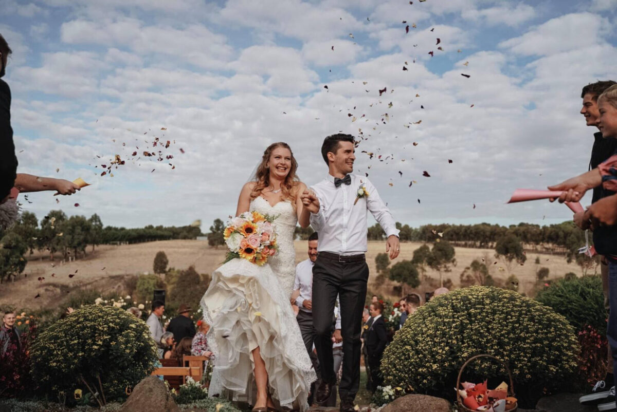 Shandar & Nathan happy on their wedding day with the sunflower bouquet